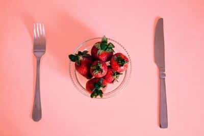 bowl of strawberries and utensils on each side