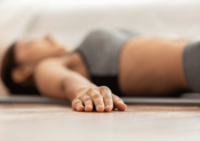 woman lying on a yoga mat in savasana