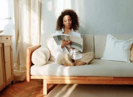 woman reading a book on a sofa