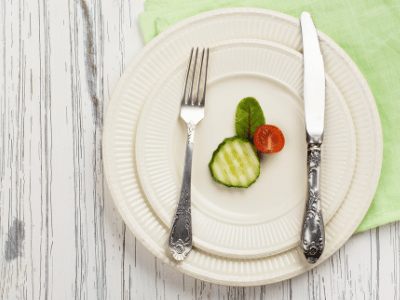 plate with just one tomato and cucumber to symbolize eating too little calories