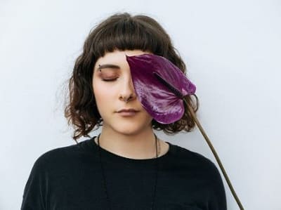 woman with her eyes closed to somehow symbolize meditating on the connection between trapped emotions and weight gain